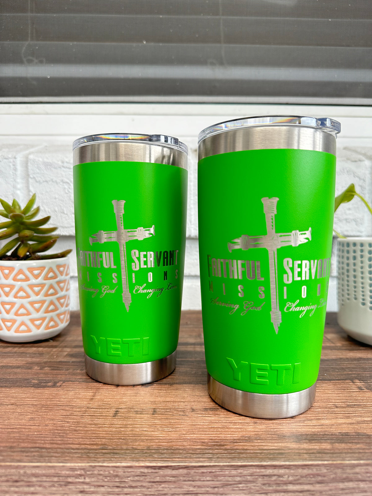 Ministry logo with a cross of nails laser engraved on two green YETI Rambler 20 oz Tumblers