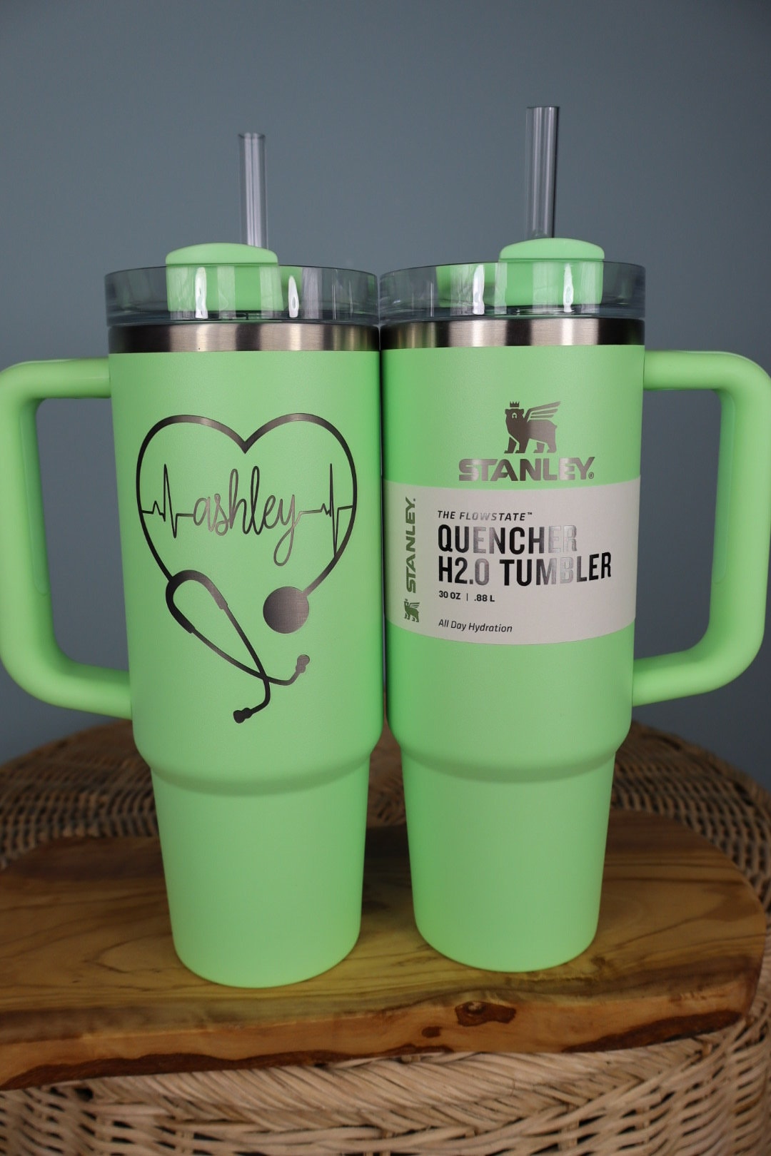A Stanley tumbler engraved with a heart and heartbeat design and a name