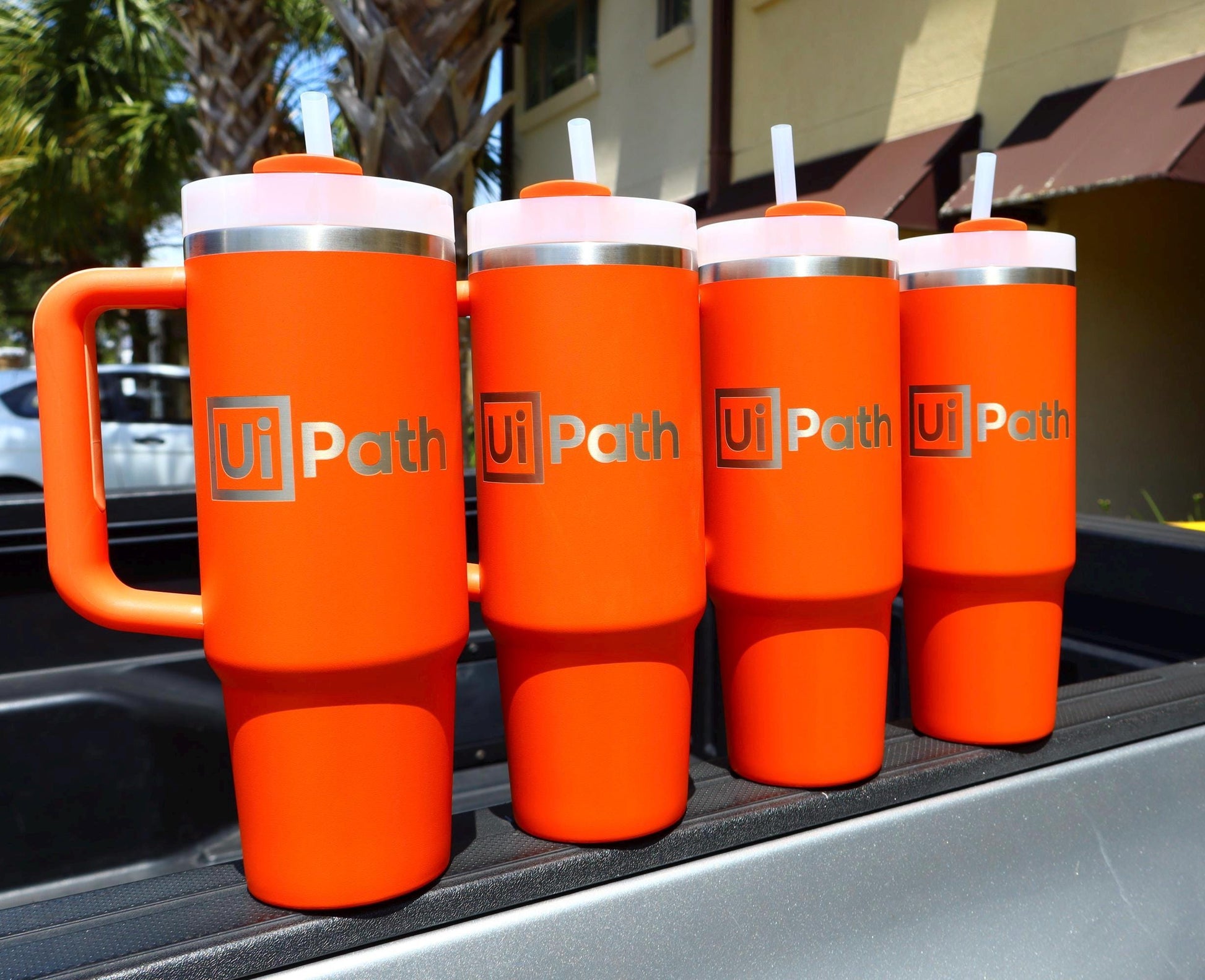 Company logo engraved on a row of orange Stanley Quenchers