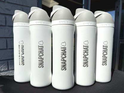 Company logo engraved on a row of white Owala FreeSip bottles